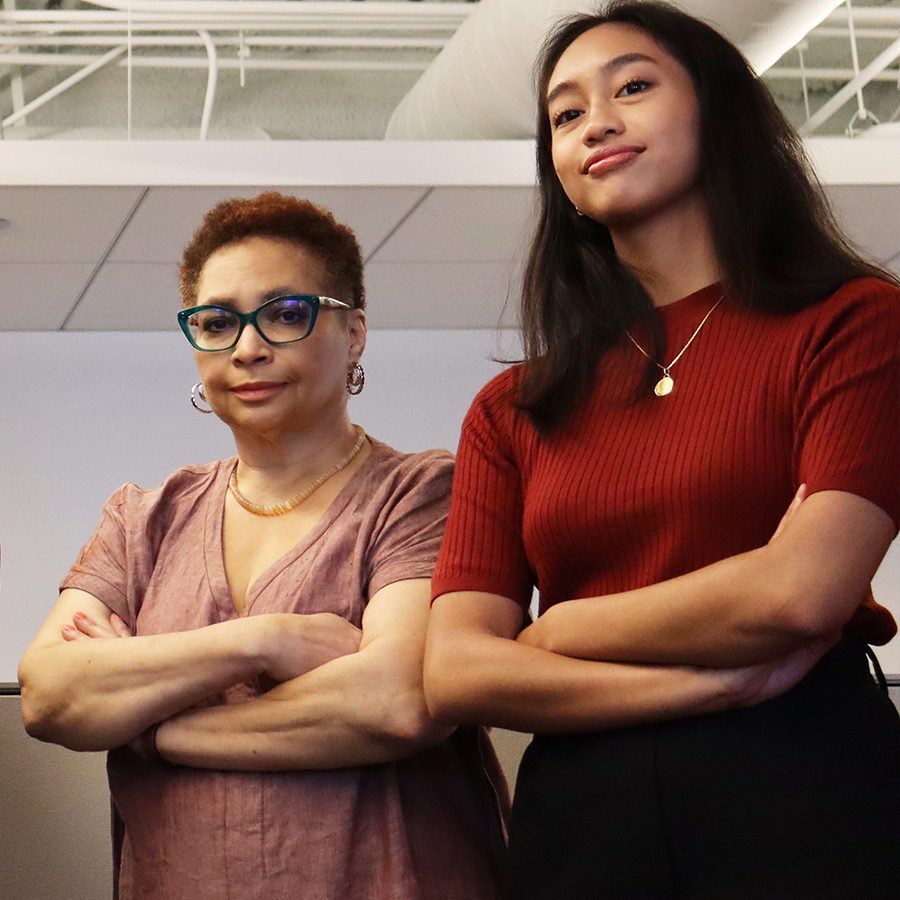 Two women posing inside an office space