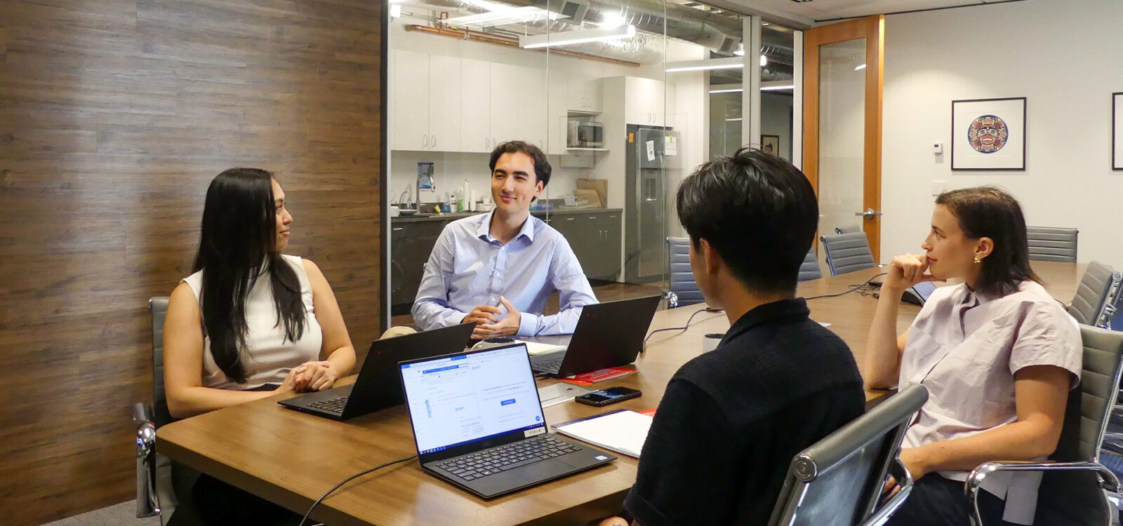 A group of team members sitting down in a conference room having a discussion.
