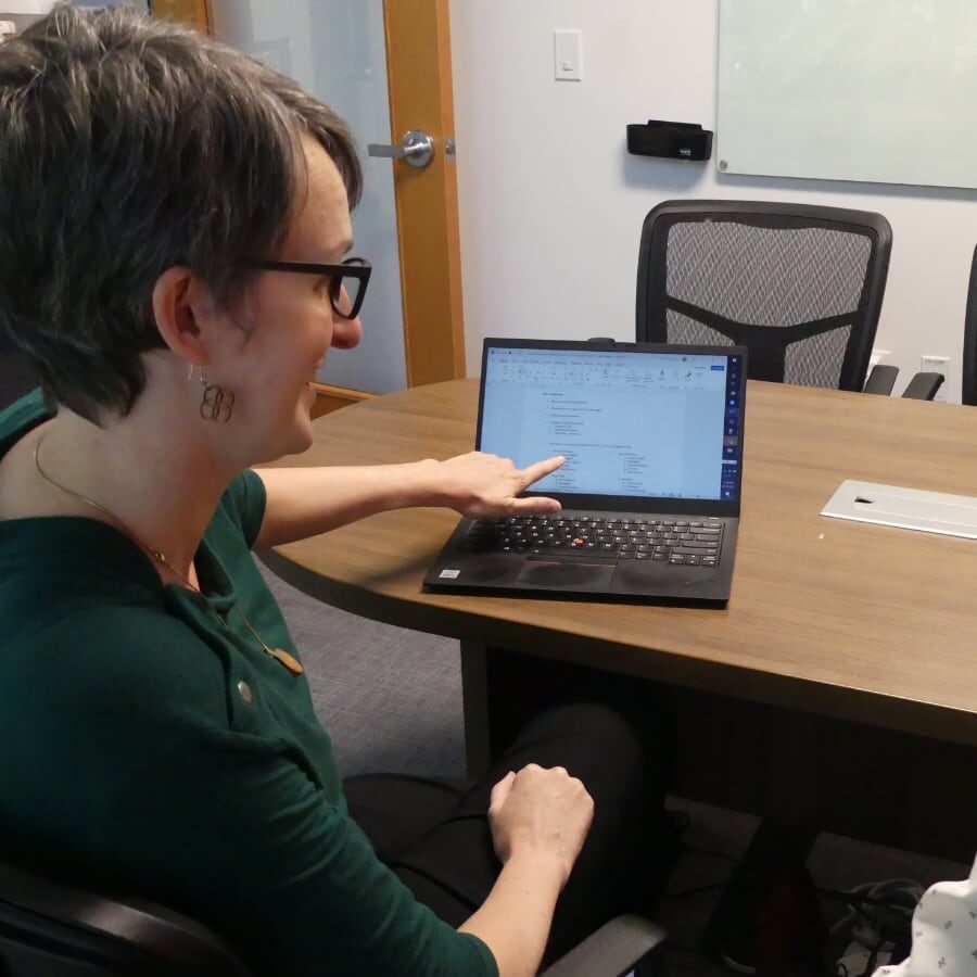 Woman pointing at laptop screen