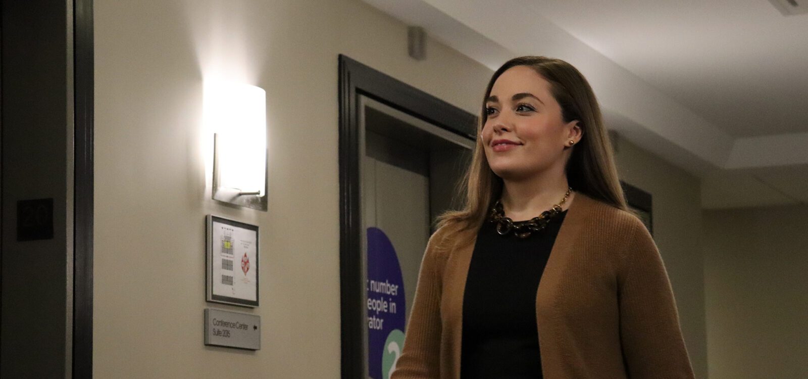 Woman smiling and walking in the hallway