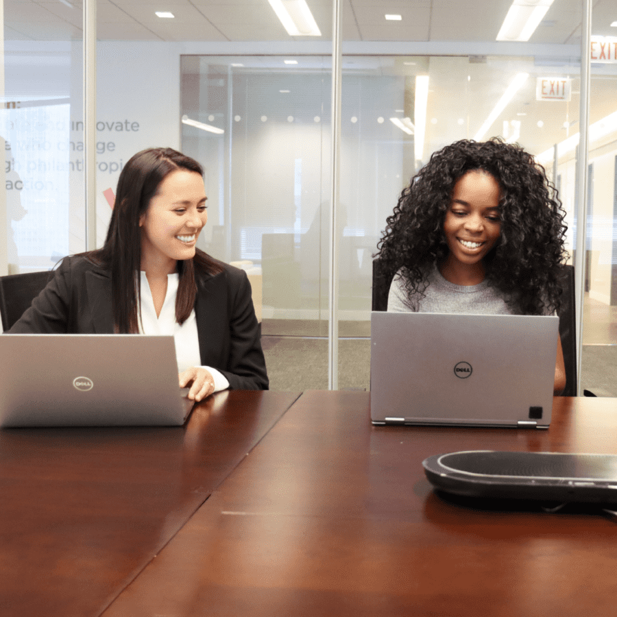 two woman working on laptops